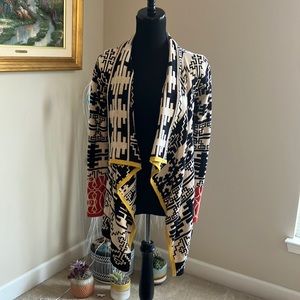 Aztec style open cardigan with waterfall detail and color block trim. Will fit M